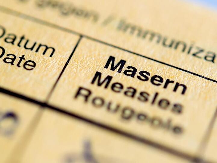 Die Aufschrift "Masern" steht auf einem Impfpass. Foto: Hauke-Christian Dittrich/Archiv