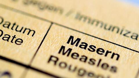 Die Aufschrift "Masern" steht auf einem Impfpass. Foto: Hauke-Christian Dittrich/Archiv