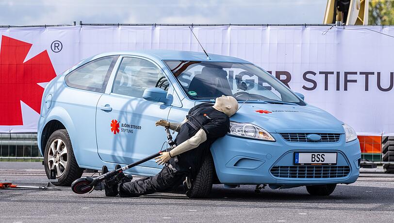Crashtest mit einem E-Scooter: Ein abbiegendes Auto erfasst den Dummy - der prallt hart auf den Wagen.