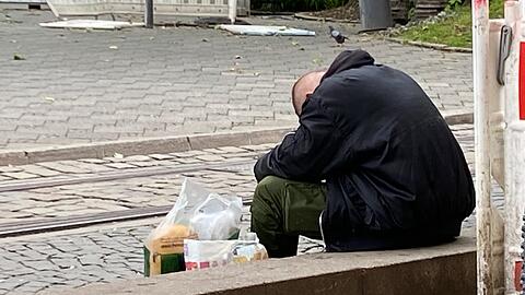 Ein Mann sitz in der Nähe der Tramhaltestelle Sendlinger Tor.