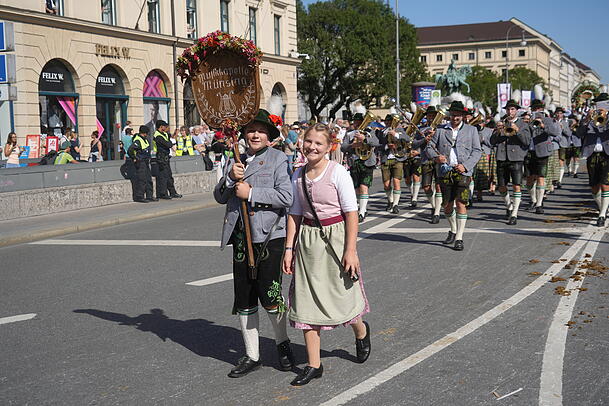 Viele Kinder tragen die Schilder ihrer Vereine. Wie hier, bei der Musikkapelle Münsing.
