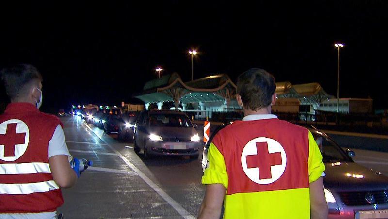 Mitarbeiter des Roten Kreuzes betreuen in der Nacht Autofahrer in einem kilometerlangen Stau bei der Einreise nach Österreich am Karawankentunnel. Mitarbeiter des Roten Kreuzes betreuen in der Nacht Autofahrer in einem kilometerlangen Stau bei der Einreise nach Österreich am Karawankentunnel.