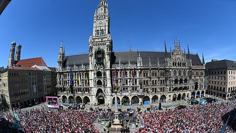 Zahlreiche Fans vom FC Bayern München feiern auf dem Marienplatz vor dem Rathaus mit den Spielern auf dem Balkon des Rathaus.
