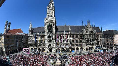 Zahlreiche Fans vom FC Bayern München feiern auf dem Marienplatz vor dem Rathaus mit den Spielern auf dem Balkon des Rathaus.