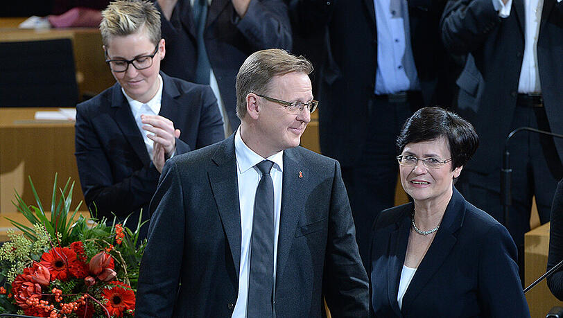 Bodo Ramelow erhält nach seiner Wahl zum neuen Ministerpräsidenten die Glückwünsche der scheidenden Ministerpräsidentin Christine Lieberknecht (r), im Hintergrund links die Landesvorsitzende der Linken, Susanne Hennig-Welsow. Bodo Ramelow erhält nach seiner Wahl zum neuen Ministerpräsidenten die Glückwünsche der scheidenden Ministerpräsidentin Christine Lieberknecht (r), im Hintergrund links die Landesvorsitzende der Linken, Susanne Hennig-Welsow.