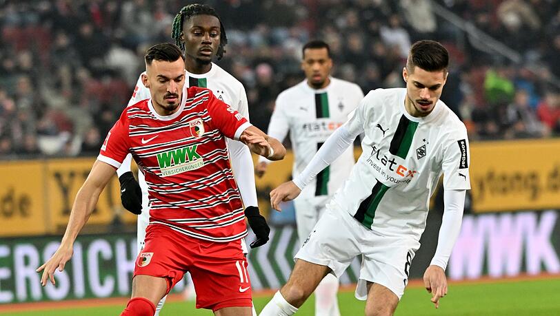 Der Augsburger Mergim Berisha (l) und Julian Weigl (r) von Mönchengladbach.