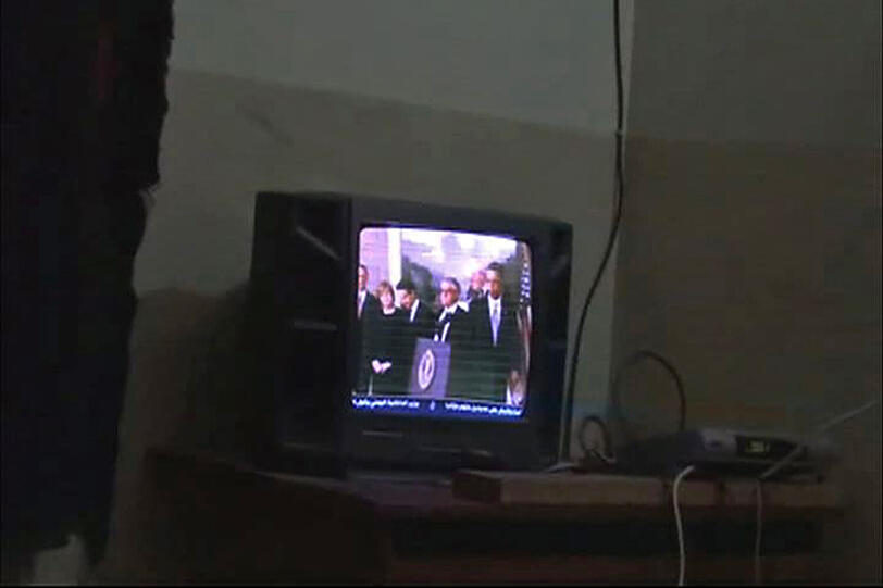 Die Szene aus einem vom Pentagon freigegebenen Video zeigt Osama bin Laden vor einem Fernseher mit einer Fernbedienung in der Hand.