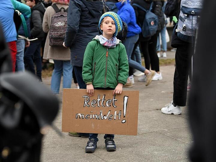 Ein sechsjähriger Teilnehmer einer Schülerdemo in Berlin hält ein Schild mit der Aufschrift "Rettet meine Welt!"