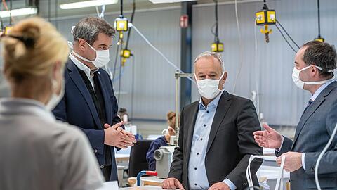 Geschäftsführer Reinhard Zettl und Hubert Aiwanger (Freie Wähler) stehen im April 2020 in der Produktionshalle des Automobilzulieferers Zettl, der auf die Produktion von Schutzmasken umgestellt hatte. Auch Ministerpräsident Markus Söder (CSU) machte sich damals vor Ort ein Bild. Der Auftrag wirft Fragen auf.
