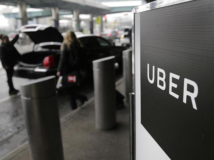 Ein Schild mit dem Logo des amerikanischen Dienstleistungsunternehmens Uber. Foto: Seth Wenig/AP/dpa/Archivbild