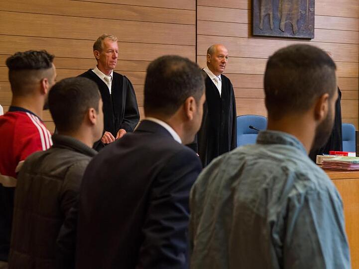 Die Angeklagten Mahmod R. (l.-r.), Muataz J., ein Dolmetscher und Ammar R. im Landgericht Traunstein. Foto: Peter Kneffel/dpa/Archivbild