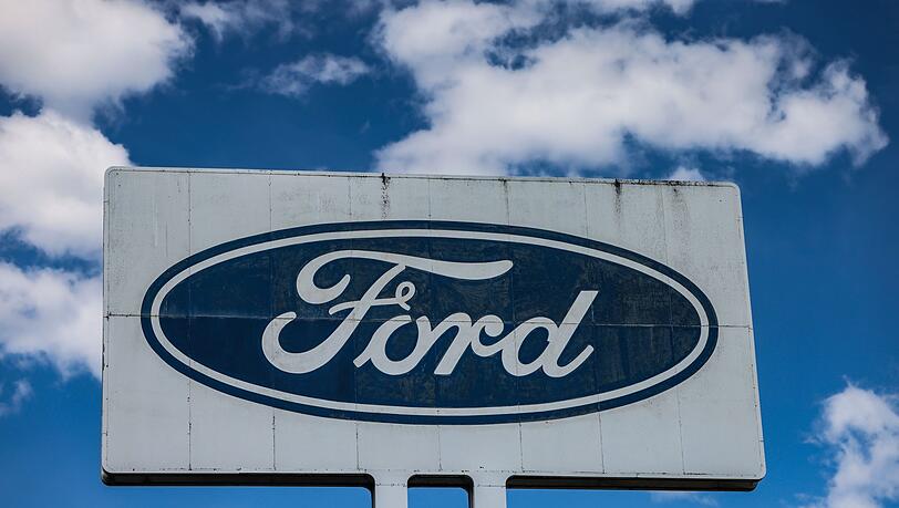 Ein Logo steht vor dem Ford Werk bei gutem Wetter - wirtschaftlich gesehen sind die Perspektiven des Ford-Autogeschäfts in Europa düster.