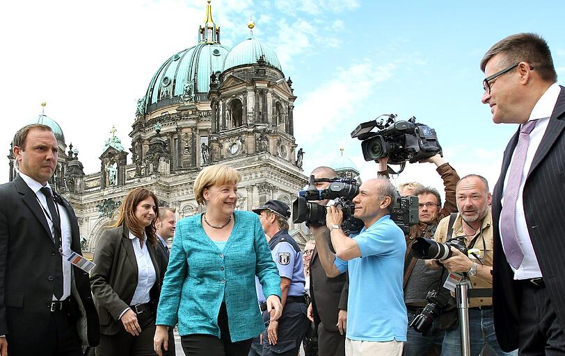 In Begleitung von Sicherheitsbeamten kommt Bundeskanzlerin Angela Merkel (CDU) am 23.06.2013 vor dem Berliner Dom in die Humboldtbox in Berlin zu den Beratungen der Präsidien von CDU und CSU. Die Politiker beraten und beschließen das Programm für die Bundestagswahl im September.