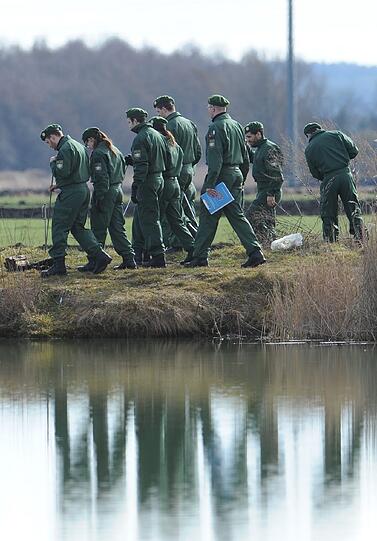 Polizisten suchen am Montag einen Weg am Ufer des Rathei-Weihers zwischen Zell und Karlshuld ab.