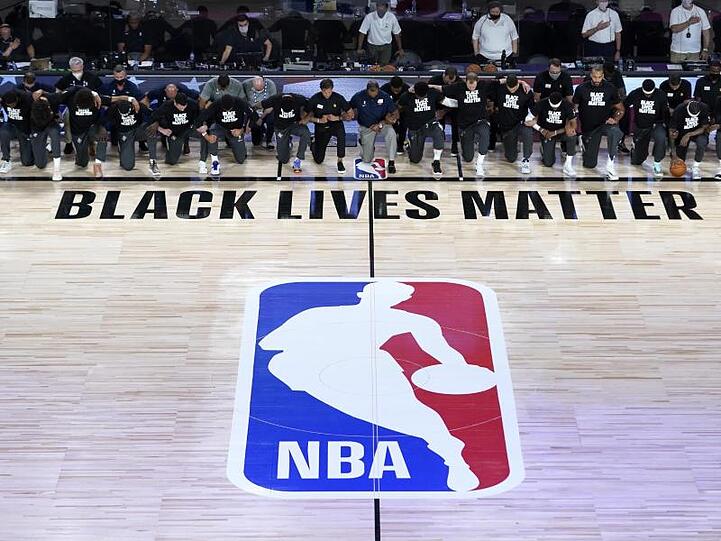 Alle Spieler der New Orleans Pelicans und von Utah Jazz knien vor einem "Black Lives Matter"-Schriftzug.