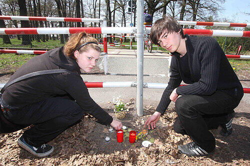 Nina (li.) und Sinan zünden immer wieder die Kerzen an. Der Sog der Züge bläst die Flammen aus.