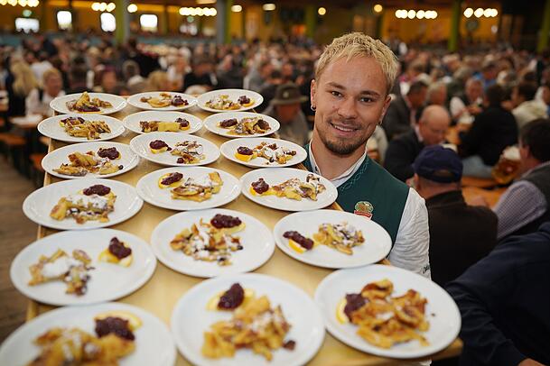 Wiesn-Kellner Benje serviert bei der Bio-Schmankerl-Tour den Kaiserschmarrn zum Probieren in der Ochsenbraterei.
