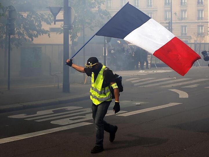 Ein Demonstrant schwenkt in Paris eine französische Flagge.