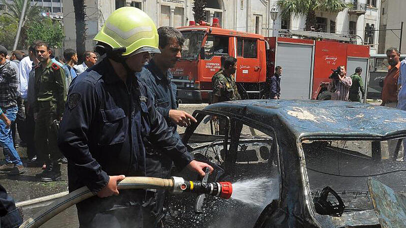 Ein Feuerwehrmann nach einer Explosion in Damaskus im Einsatz. Nun hat es am Flughafen der Stadt mehrere Explosionen gegeben.