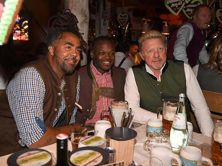 Der ehemalige Fußballer Patrick Owomoyela (l-r), Raphael de Souza und Boris Becker feiern beim Almauftrieb im Käferzelt.