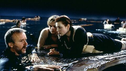 Regisseur James Cameron (l.), Leonardo DiCaprio und Kate Winslet am Set von "Titanic" mit der berühmt-berüchtigten Tür.