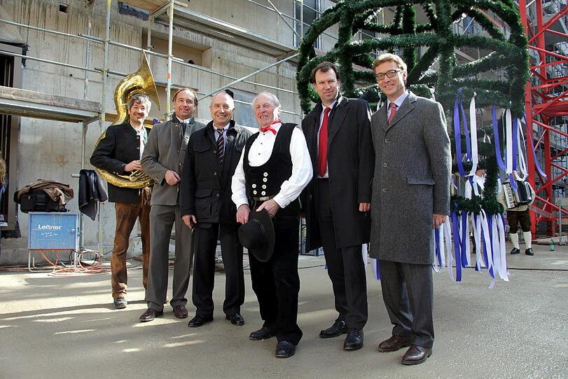 Von einem Tubaspieler und einem Zimmermann begleitet: GBW-Vorstand Claus Lehner, Vorstandsvorsitzender Ernst Holland, Vorstand Matthias Steinhauer und Projektleiter Christian Link (v.li.)