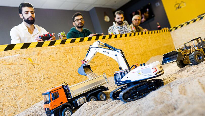 Gr&uuml;nder Siymo Othman (links) steuert mit Freunden kleine Bagger, Radlader und Lastwagen in seinem neu er&ouml;ffneten Bagger-Caf&eacute;. Es soll das erste dieser Art in Deutschland sein.