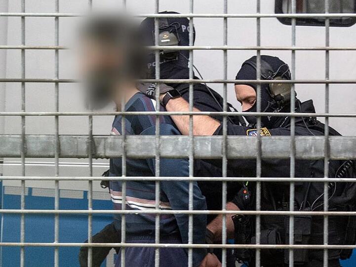 Vermummte Beamte einer Spezialeinheit der Polizei bringen den terrorverdächtigen Mann zur Haftvorführung am Gericht.
