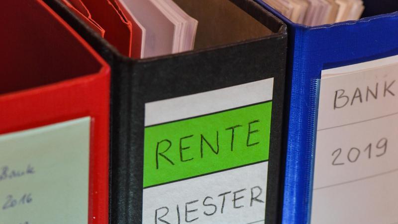 Ein Ordner mit der Aufschrift "Rente Riester Vertrag" steht zwischen anderen Aktenordnern. Ein Ordner mit der Aufschrift "Rente Riester Vertrag" steht zwischen anderen Aktenordnern.