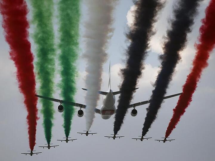 Ein Airbus A380 der Fluggesellschaft Emirates und Al Fursan, das Kunstflugvorführteam der Luftwaffe der Vereinigten Arabischen Emirate, treten während der Dubai Air Show 2013.