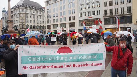Fordern auch Gleichbehandlung bei staatlicher Hilfe: Reiseleiter demonstrierten am Freitag im Regen auf dem Marienplatz.