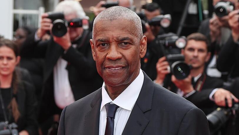 Denzel Washington kam im dunklen Anzug zur Premiere in Cannes. Dort wurde er mit der Goldenen Ehrenpalme überrascht.