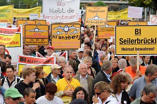 Demonstranten halten am Flughafen in München Transparente und Schilder in den Händen, um gegen die dritte Startbahn zu protestieren.