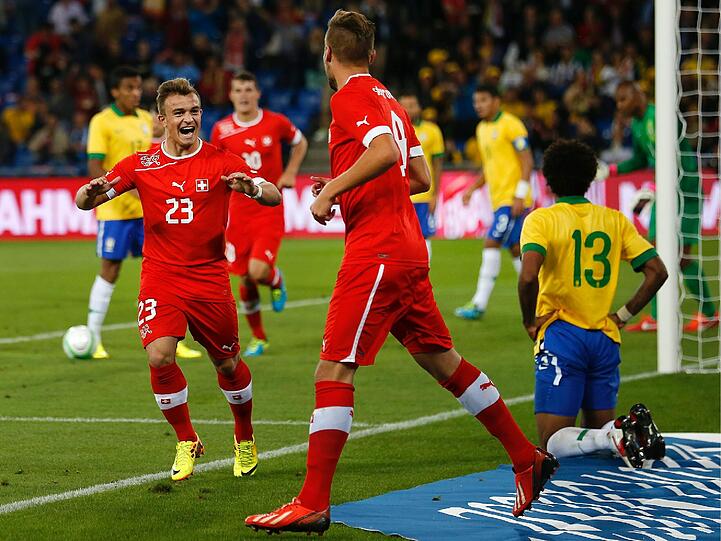 Der eine jubelt, der andere ist konsterniert: Der Schweizer Xherdan Shaqiri freut sich über das 1:0 gegen die Brasilianer, sein Bayern-Kollege Dante (Nr. 13) trauert. Foto: dpa