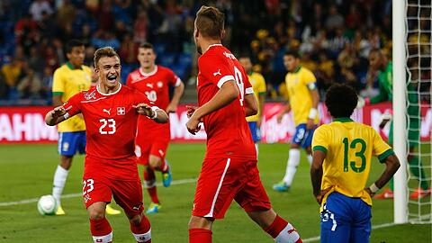 Der eine jubelt, der andere ist konsterniert: Der Schweizer Xherdan Shaqiri freut sich über das 1:0 gegen die Brasilianer, sein Bayern-Kollege Dante (Nr. 13) trauert. Foto: dpa