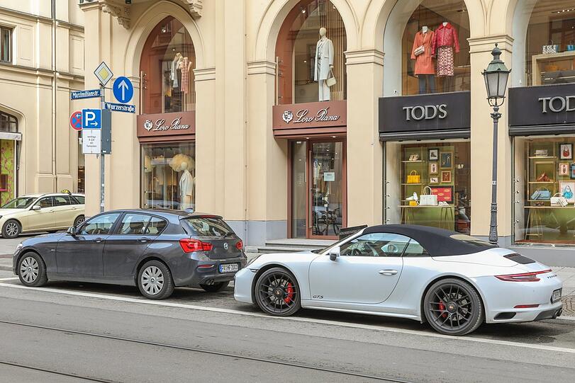 Die Parkplätze sind voll, noch sind nur wenige teure Autos unterwegs, wie dieser Porsche. Dass die Parkplätze alle weg sollen, stößt in den Edelläden nicht auf Begeisterung.