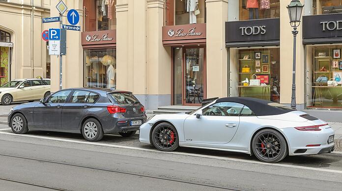 Die Parkplätze sind voll, noch sind nur wenige teure Autos unterwegs, wie dieser Porsche. Dass die Parkplätze alle weg sollen, stößt in den Edelläden nicht auf Begeisterung.