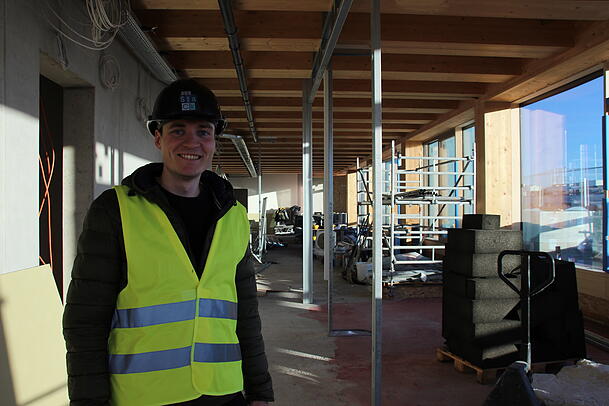 Projektleiter Daniel Giesler auf der S&uuml;dseite von "The Stack": Die Holztr&auml;ger aus Fichte verleihen dem Rohbau schon jetzt ein Wohlf&uuml;hl-Ambiente.