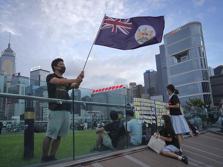Ein Demonstrant schwenkt die britische Kolonialflagge von Hongkong in einem Park.