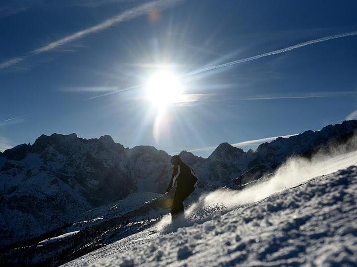 Ein Skifahrer fährt bei Sonnenschein auf der Piste. Foto: Angelika Warmuth/Archiv