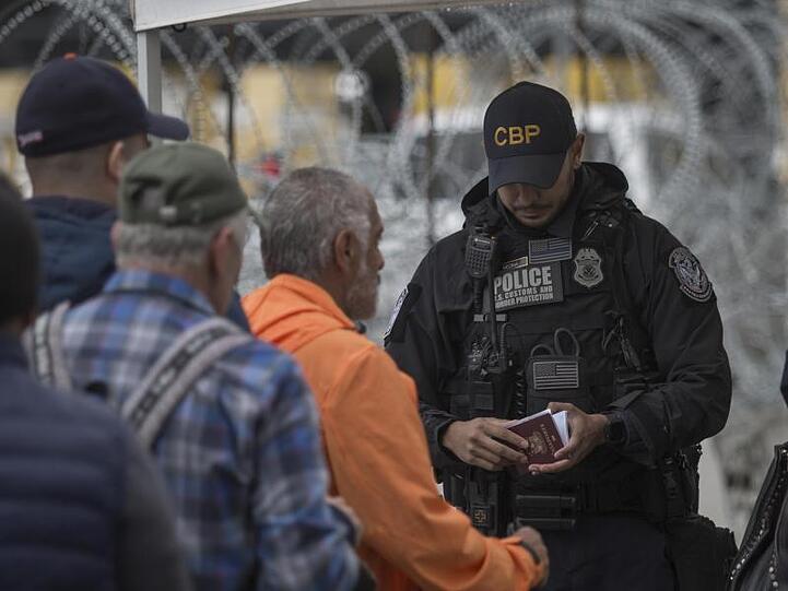 Ein Grenzbeamter kontrolliert in Tijuana am Grenzübergang zwischen Mexiko und den USA einen Pass.