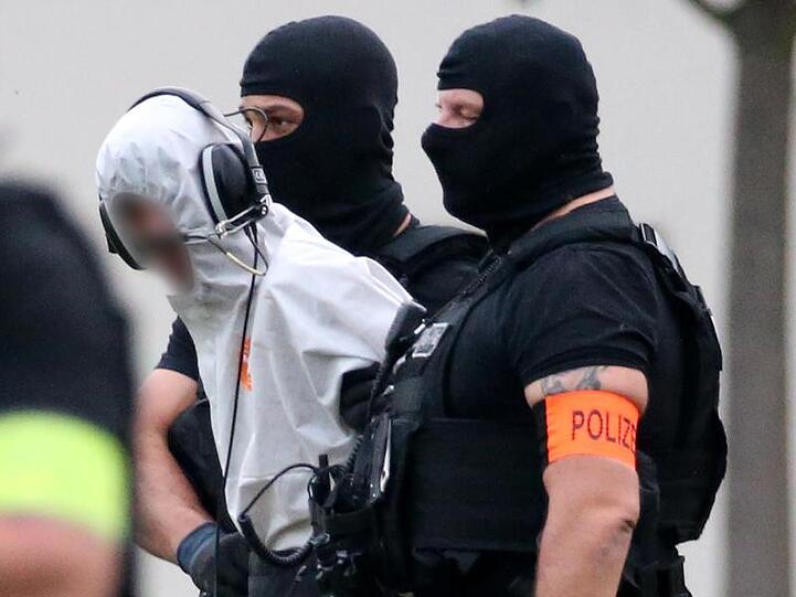 Ali B. wird von Beamten einer polizeilichen Spezialeinheit aus dem Justizzentrum zu einem Polizeihubschrauber gebracht.