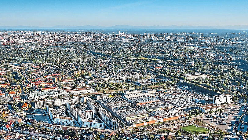 Die Meiller-Gärten (l.) und der Betrieb in Moosach (r.) aus der Luft: In 25 Hallen hat die Meiller Gruppe 70.000 Quadratmeter überdachte Produktionsfläche. Die Dächer sind teils begrünt und mit Fotovoltaik ausgestattet.