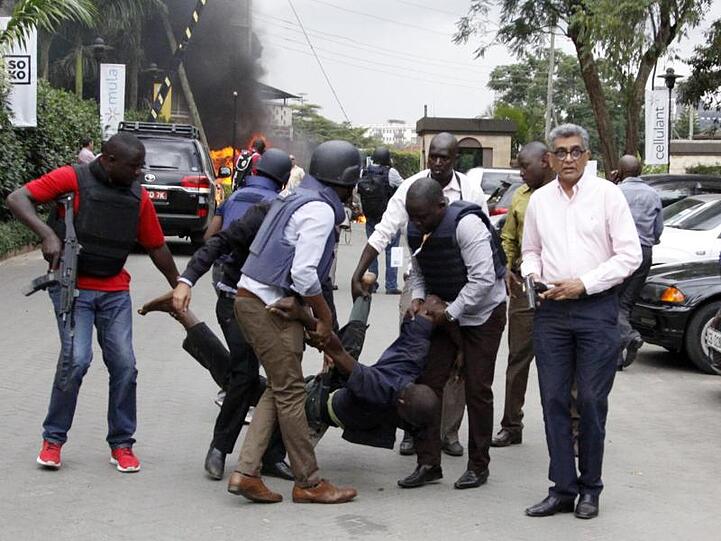 Sicherheitskräfte helfen einem Mann am Schauplatz der Explosion in Kenias Hauptstadt Nairobi.