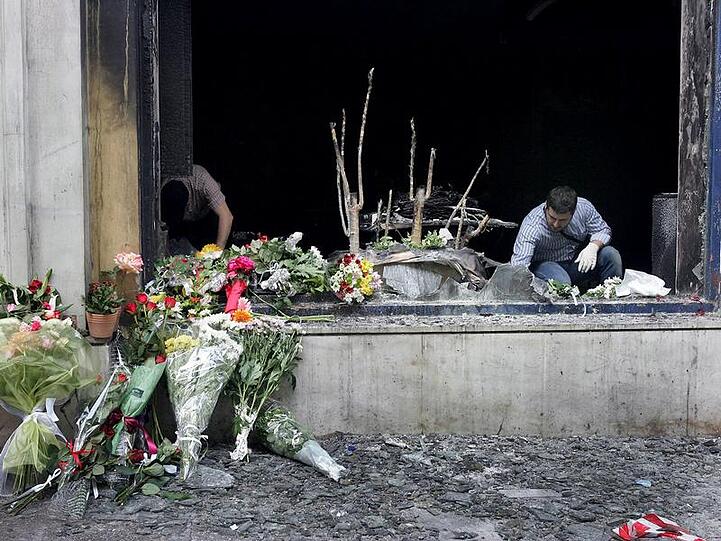 Blumen vor der ausgebrannten Bankfiliale in Athen