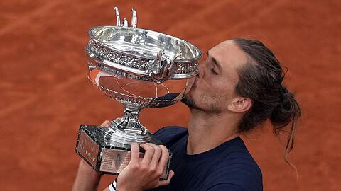 Alexander Zverev gibt der Troph&auml;e einen Kuss.