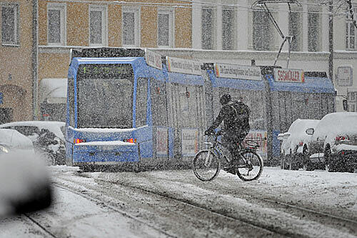 in Fahrradfahrer kämpft sich am Montag mit seinem Drahtesel über die verschneiten Straßen in München
