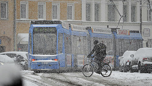 in Fahrradfahrer kämpft sich am Montag mit seinem Drahtesel über die verschneiten Straßen in München in Fahrradfahrer kämpft sich am Montag mit seinem Drahtesel über die verschneiten Straßen in München