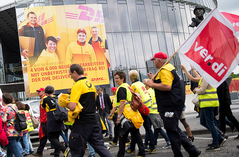 Mitarbeiter der Post gehen während einer Demonstration in Bonn an der Konzernzentrale vorbei.
