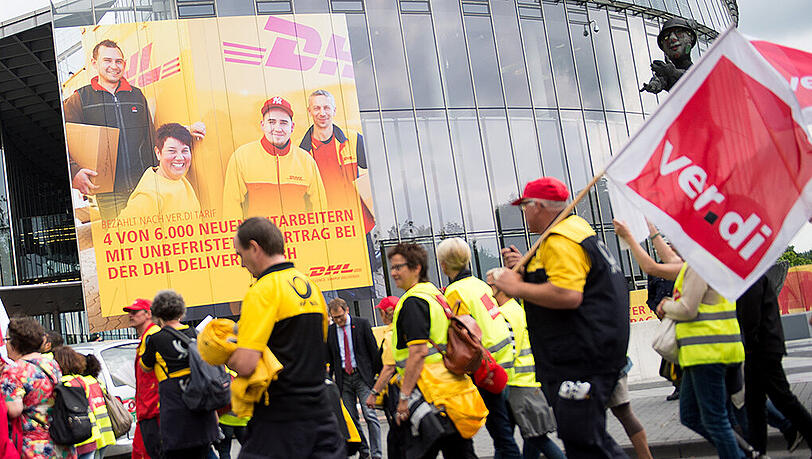 Mitarbeiter der Post gehen während einer Demonstration in Bonn an der Konzernzentrale vorbei. Mitarbeiter der Post gehen während einer Demonstration in Bonn an der Konzernzentrale vorbei.